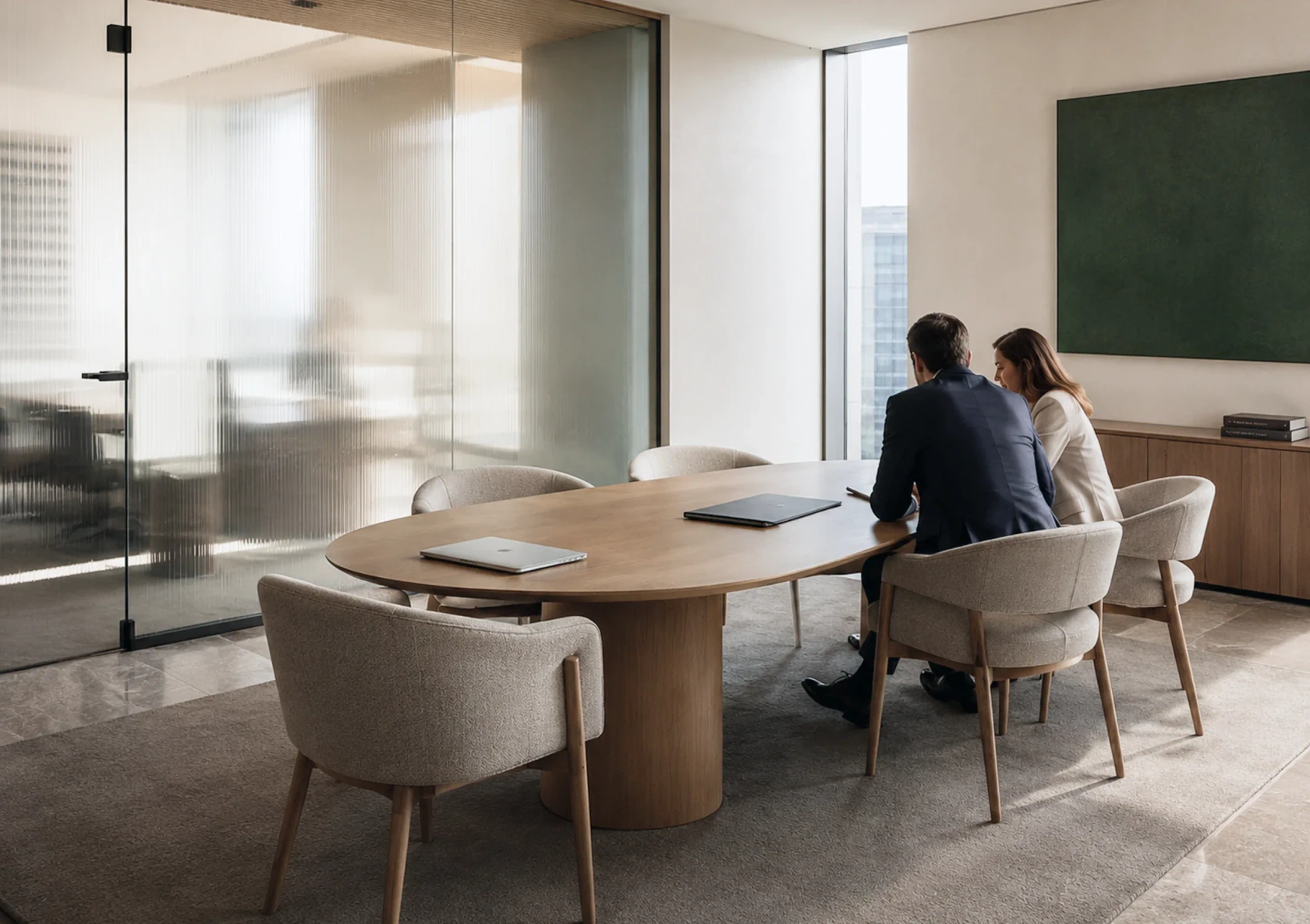 Two colleagues working together at an oval meeting table